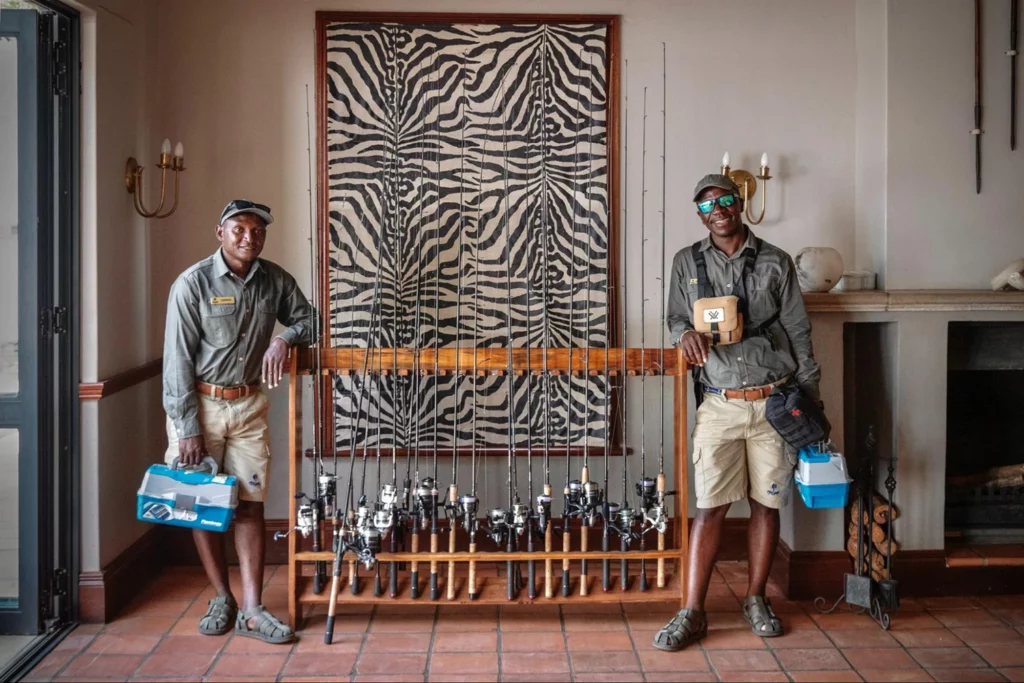 Two smiling Baines River Camp safari guides inside the lodge